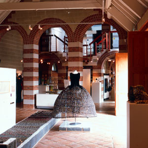 A gallery displaying a dress, a 'road' of fabric, and other pieces.
