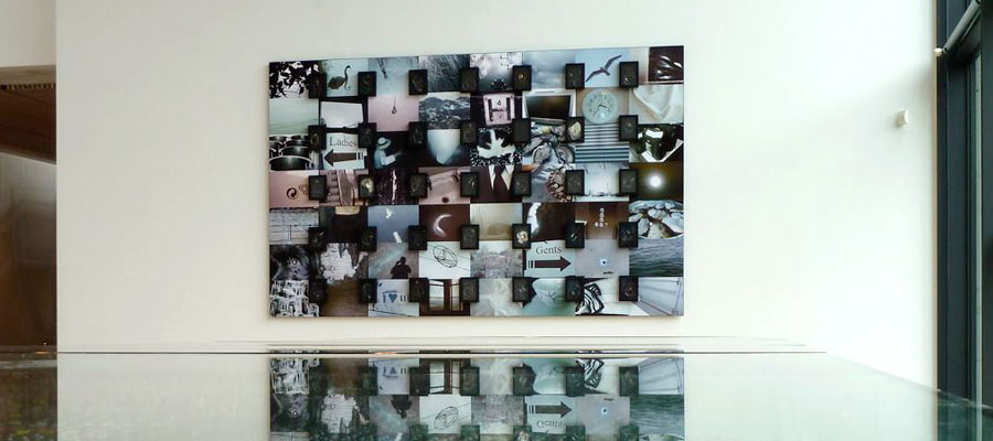 Monochromatic photo montage in gallery, covered in black framed butterfly needles